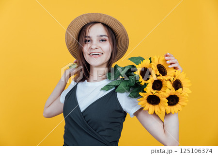 Beautiful woman smiling with yellow sunflower flowers Beautiful woman smiling with yellow sunflower flowers 125106374