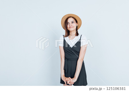 Beautiful fashion woman in sundress and hat smiling on white background 125106381