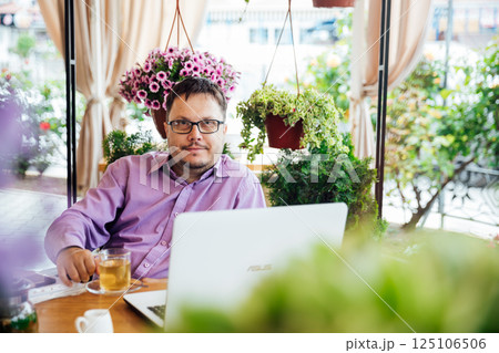 Man working on laptop online at table with food Man working on laptop online at table with food 125106506
