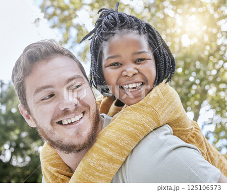 Park, piggyback and father with girl kid in nature playing, bonding and exploring with bokeh. Happy, smile and portrait of an interracial child with her dad in an outdoor green garden or field. 125106573