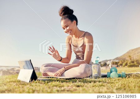 Fitness, woman and tablet call for yoga exercise, training or workout on the grass in the outdoors. Happy female waving for video call on touchscreen in spiritual wellness, zen or lifestyle in nature 125106985