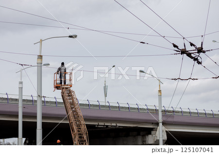 Electrician works on tower above city's electrical networks. Electrician works on tower above city's electrical networks. 125107041