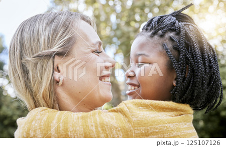 Hug, smile and mother love with girl in a nature park with love, foster care and diversity. Happy, relax and hugging mom and adopted kid bonding together in summer on mothers day or holiday outdoor Hug, smile and mother love with girl in a nature park with love, foster care and diversity. Happy, relax and hugging mom and adopted kid bonding together in summer on mothers day or holiday outdoor 125107126
