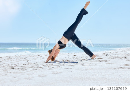 Beach, yoga and woman pilates with balance, workout wellness and meditation on sea sand. Athlete with fitness, exercise and zen pose stretching for peace, relax and sports training outdoor by ocean Beach, yoga and woman pilates with balance, workout wellness and meditation on sea sand. Athlete with fitness, exercise and zen pose stretching for peace, relax and sports training outdoor by ocean 125107659