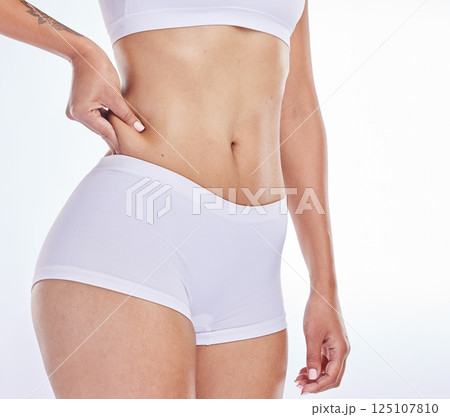 Stomach fat, weight loss and woman feeling workout, training and healthy diet progress. Female model check body wellness, health and belly exercise fitness for wellbeing and abs muscle growth 125107810