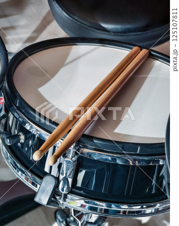 Snare drum and drumsticks resting on a drummer's setup waiting for the next beat Snare drum and drumsticks resting on a drummer's setup waiting for the next beat 125107811