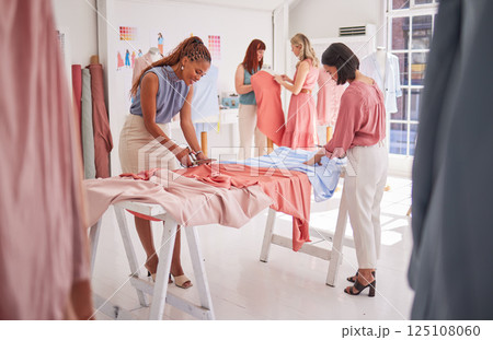 Business people, fashion and design working with fabric, material or clothing in teamwork at the office. Group of employee designers busy with garment or outfit together on team project in the studio 125108060