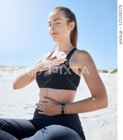 Yoga, meditation and beach fitness of a woman athlete with a zen prayer and mindfulness in nature. Meditate, peace and wellness exercise by the ocean sand for chakra, workout and relax sea pilates 125108178