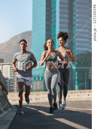 Diversity, fitness friends and running together in city for freedom or healthy lifestyle motivation. Runner athlete, sports training team and wellness coach outdoor workout for cardio exercise goal Diversity, fitness friends and running together in city for freedom or healthy lifestyle motivation. Runner athlete, sports training team and wellness coach outdoor workout for cardio exercise goal 125108348
