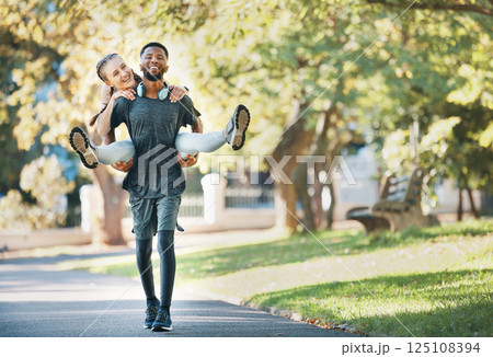 Interracial couple, piggy back and outdoor with smile for fitness, health and exercise in park. Runner, black man and woman on back in workout, running or wellness in urban sunshine by trees together Interracial couple, piggy back and outdoor with smile for fitness, health and exercise in park. Runner, black man and woman on back in workout, running or wellness in urban sunshine by trees together 125108394