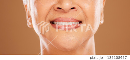 Teeth, dental and senior woman in studio isolated on a brown background. Oral care, wellness or closeup smile of elderly female model with natural looking veneers for beauty and healthy tooth hygiene Teeth, dental and senior woman in studio isolated on a brown background. Oral care, wellness or closeup smile of elderly female model with natural looking veneers for beauty and healthy tooth hygiene 125108457
