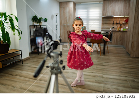 Little dancer performs gracefully in a cozy home space while being filmed for a fun project 125108932