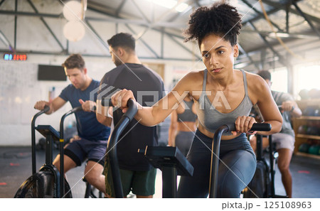 Fitness, class and bike workout of a black woman in a cycling, training and exercise studio. Bicycle sport, gym wellness and sports health club with a person on a machine with athlete motivation Fitness, class and bike workout of a black woman in a cycling, training and exercise studio. Bicycle sport, gym wellness and sports health club with a person on a machine with athlete motivation 125108963