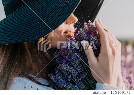 Woman in a Wide-Brimmed Hat Sniffing Lavender 125109172