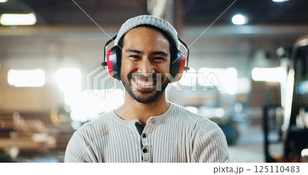 Carpenter, man and portrait with headphones in workshop for woodwork, furniture production or hearing protection. Manufacturing industry, worker and happy in warehouse for carpentry or small business Carpenter, man and portrait with headphones in workshop for woodwork, furniture production or hearing protection. Manufacturing industry, worker and happy in warehouse for carpentry or small business 125110483