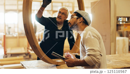 Carpenter, discussion and man with tablet in workshop for framework inspection, safety compliance or quality control. Manufacturing, people and team with structure evaluation and furniture production 125110567