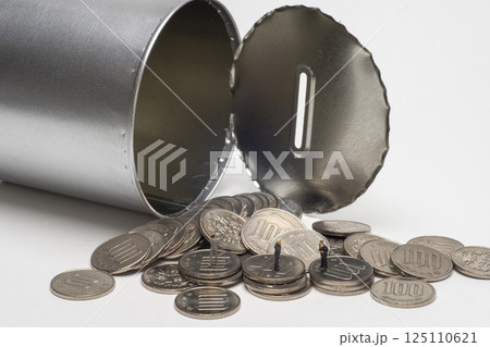 開けられた缶型の貯金箱とコイン 125110621