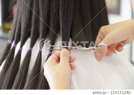 ヘアドネーションの髪の毛をカットする女性 ヘアドネーションの髪の毛をカットする女性 125111280