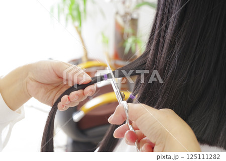 ヘアドネーションの髪の毛をカットする女性 ヘアドネーションの髪の毛をカットする女性 125111282