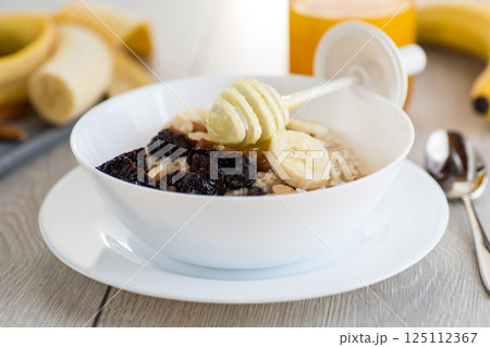 Healthy and nutritious breakfast with oatmeal and honey 125112367