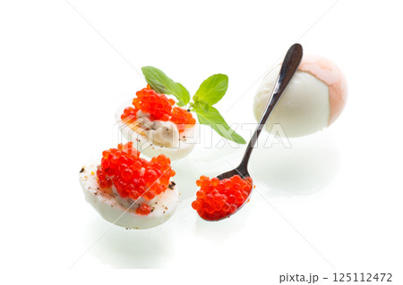 boiled eggs with red caviar on a white background 125112472