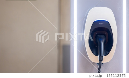 EV charging station and electric car, Electric car charging station for charge EV battery, Plug for vehicle with electric engine, EV charger clean energy, Charging point at car parking lot. EV charging station and electric car, Electric car charging station for charge EV battery, Plug for vehicle with electric engine, EV charger clean energy, Charging point at car parking lot. 125112573