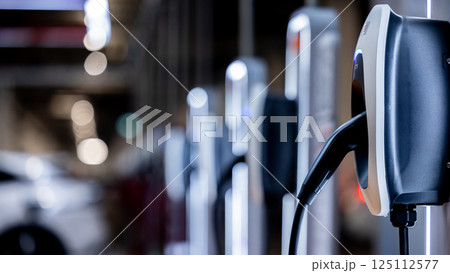 EV charging station and electric car, Electric car charging station for charge EV battery, Plug for vehicle with electric engine, EV charger clean energy, Charging point at car parking lot. EV charging station and electric car, Electric car charging station for charge EV battery, Plug for vehicle with electric engine, EV charger clean energy, Charging point at car parking lot. 125112577