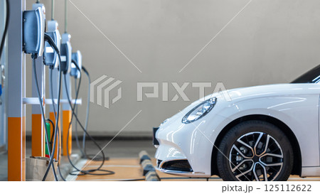 EV charging station and electric car, Electric car charging station for charge EV battery, Plug for vehicle with electric engine, EV charger clean energy, Charging point at car parking lot. EV charging station and electric car, Electric car charging station for charge EV battery, Plug for vehicle with electric engine, EV charger clean energy, Charging point at car parking lot. 125112622