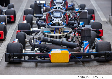 Race go kart car in row on the pit lane, Racing kart wait for race, Go kart car park on race track, Row of go kart car ready to race. 125112806