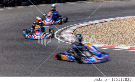 Motion blur kart driver drive go kart on kart race track circuit, Go kart racer driver on curve race track, Extreme sport 125112820
