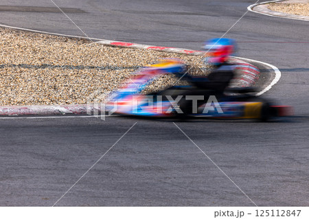 Motion blur kart driver drive go kart on kart race track circuit, Go kart racer driver on curve race track, Extreme sport 125112847