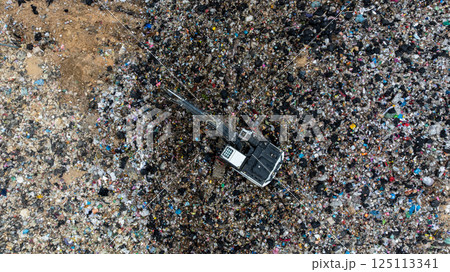 Garbage dump pile in trash dump or landfill, Landfill with waste disposal, Garbage truck unloads rubbish in landfill, Truck waste dump waste from household, Excavator work garbage waste, Aerial view. 125113341