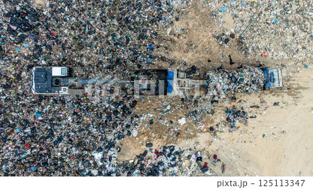 Garbage dump pile in trash dump or landfill, Landfill with waste disposal, Garbage truck unloads rubbish in landfill, Truck waste dump waste from household, Excavator work garbage waste, Aerial view. Garbage dump pile in trash dump or landfill, Landfill with waste disposal, Garbage truck unloads rubbish in landfill, Truck waste dump waste from household, Excavator work garbage waste, Aerial view. 125113347