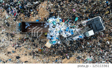 Garbage dump pile in trash dump or landfill, Landfill with waste disposal, Garbage truck unloads rubbish in landfill, Truck waste dump waste from household, Excavator work garbage waste, Aerial view. 125113361