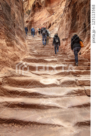 Tourists climbing ancient stone steps in petra, jordan Tourists climbing ancient stone steps in petra, jordan 125113568