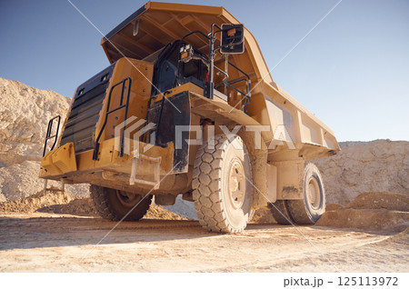 View from below of haul truck that is parked in the quarry at sunny daytime 125113972