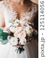Bride holding big and beautiful wedding bouquet with flowers Bride holding big and beautiful wedding bouquet with flowers 125114056