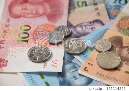 Many of different Chinese yuan banknotes. Chinese paper currency Yuan renminbi banknotes and coins as background. Many of different Chinese yuan banknotes. Chinese paper currency Yuan renminbi banknotes and coins as background. 125114223