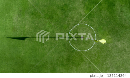 Top view putting green with flag at golf course, Golf Course with putting green, Golf course sport, green grass on golf field, fairway and putting green top view. Top view putting green with flag at golf course, Golf Course with putting green, Golf course sport, green grass on golf field, fairway and putting green top view. 125114264