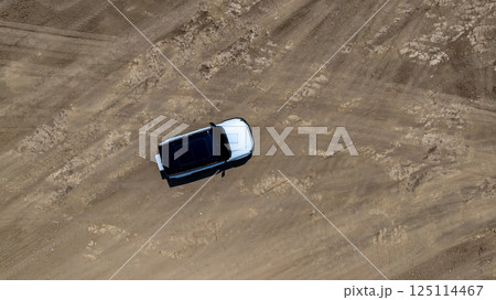 White electric car driving on dirt road, White electric car vehicle passing through dirt road, White electric vehicle car offroad 4wd, 4x4 off road ev car. White electric car driving on dirt road, White electric car vehicle passing through dirt road, White electric vehicle car offroad 4wd, 4x4 off road ev car. 125114467