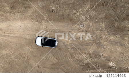 White electric car driving on dirt road, White electric car vehicle passing through dirt road, White electric vehicle car offroad 4wd, 4x4 off road ev car. 125114468