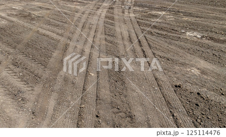 Tyre track on dirt sand or mud off road track, Tire mark ground vehicle wheel shape, Dirt soil texture, Top view tires tracks on dry mud background and texture. 125114476