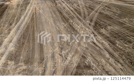Tyre track on dirt sand or mud off road track, Tire mark ground vehicle wheel shape, Dirt soil texture, Top view tires tracks on dry mud background and texture. Tyre track on dirt sand or mud off road track, Tire mark ground vehicle wheel shape, Dirt soil texture, Top view tires tracks on dry mud background and texture. 125114479