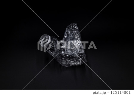 Crushed plastic water bottle on black background, Save the environment, Twisted plastic water bottle on black background. 125114801