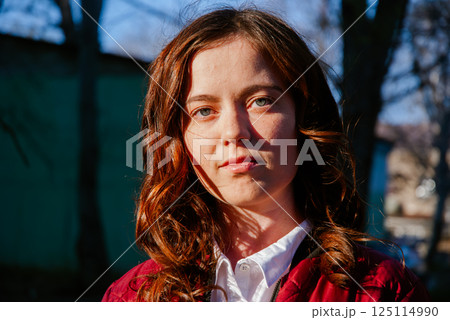 Outdoor portrait of a woman with natural light highlighting casual spring style 125114990