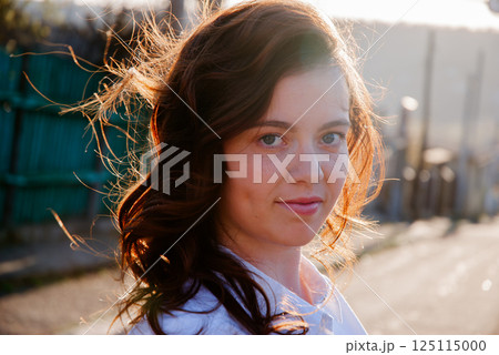 Portrait of a woman smiling in sunlight outdoors Portrait of a woman smiling in sunlight outdoors 125115000