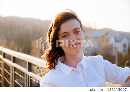 Woman in white shirt smiling on a sunny day outdoors Woman in white shirt smiling on a sunny day outdoors 125115007