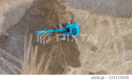 Excavator digs move earth at construction site, Excavator working and digging at construction site, Crawler excavator digger earth gravel on transportation truck at construction site, Top view 125115030