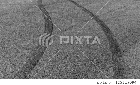 Car tire mark burnout on asphalt road race track, Abstract car tire mark from car on the asphalt road, Tire mark on race track texture and background, Black tire track skid mark on asphalt road. 125115094