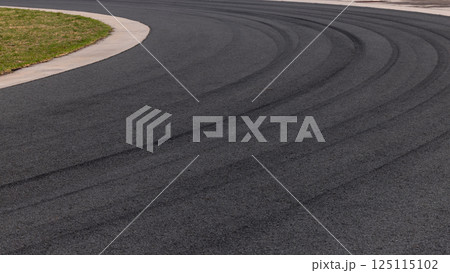 Tire mark on curve race track, Abstract black tire mark on race track, Abstract background black tire mark skid on asphalt road racing circuit, Tire track on curve road race speed track circuit. Tire mark on curve race track, Abstract black tire mark on race track, Abstract background black tire mark skid on asphalt road racing circuit, Tire track on curve road race speed track circuit. 125115102